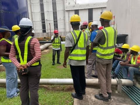 Crew briefing on site, everyone in hi-vis and hard hats