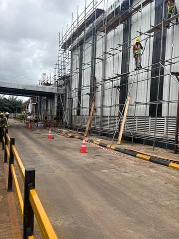 Scaffold along the plant wall with a worker at height