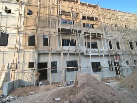 Multi-storey block building behind bamboo scaffolding